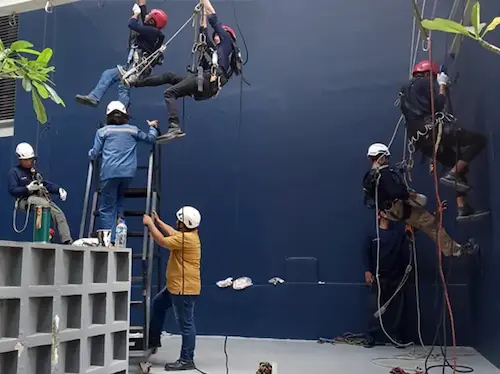 Simulasi penggunaan full body harness pada pelatihan kerja di ketinggian.