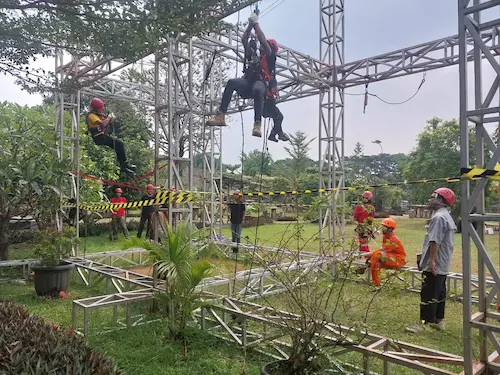 Peserta melakukan latihan pemanjatan dengan pengawasan instruktur.